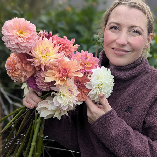 Iseult Leonard with a handful of colorful dahlia blooms