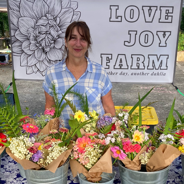 Claire Reynolds at a farmers market with buckets of bouquets