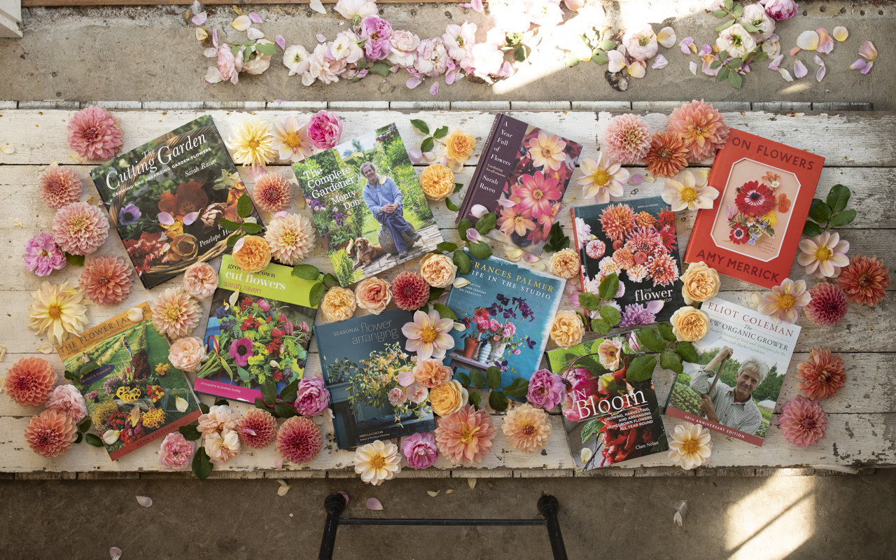 Overhead of Floret's favorite books surrounded by dahlias and roses